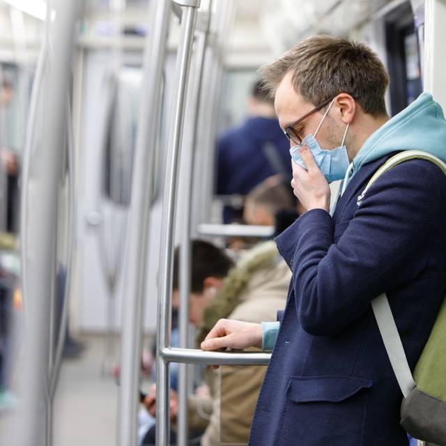 Ein kranker Mann fühlt sich schlecht – er trägt eine Atemschutzmaske gegen Infektionen.