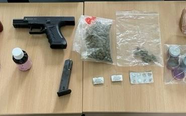 Waffe, Drogen und Tabletten auf einem Tisch.