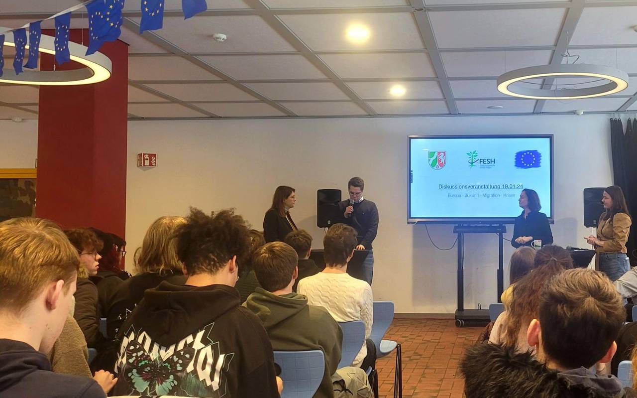 Man sieht Katarina Barley und Ina Blumenthal, die auf dem Podium in der Mensa der Gesamtschule Wehringhausen mit zwei Schülermoderatoren diskutieren