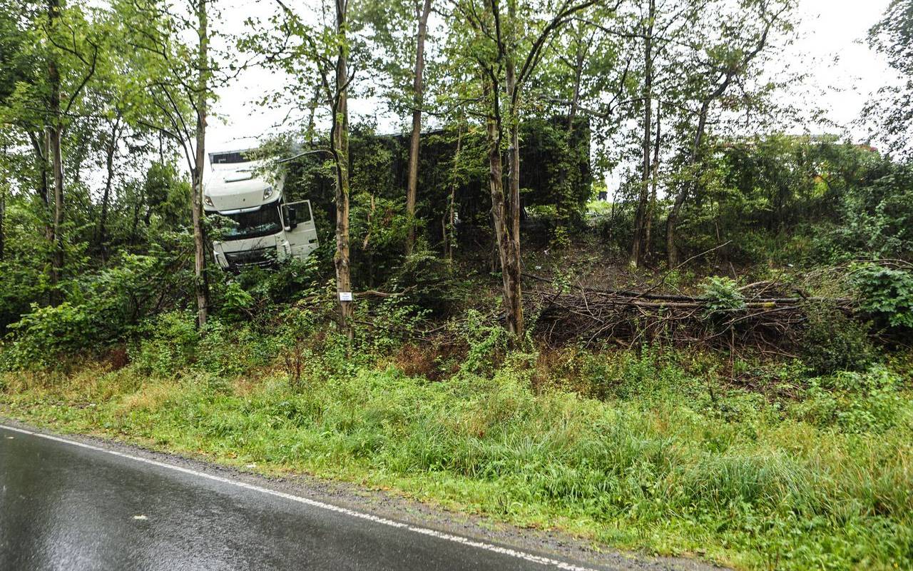 Ein Lkw hängt zwischen mehreren Bäumen