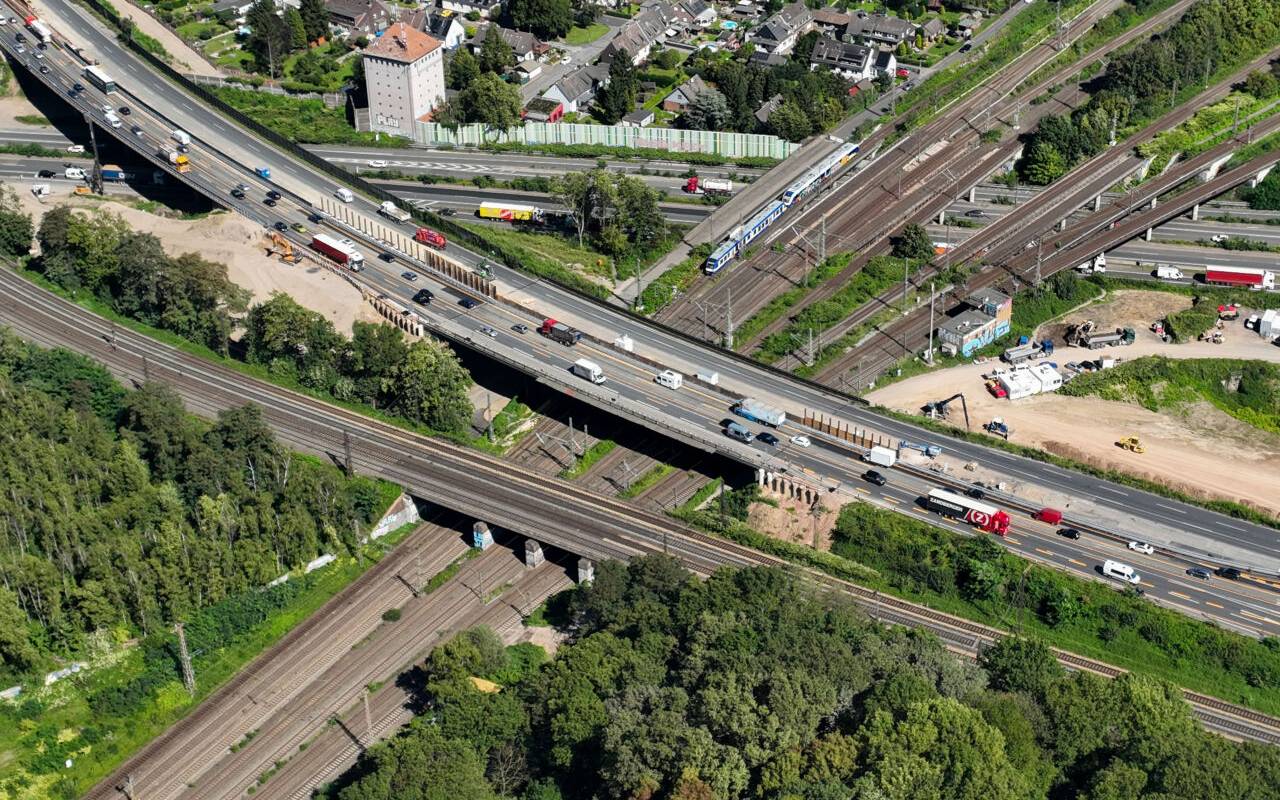 Aus der Vogelperspektive ist das Autobahnkreuz Kaiserberg in Duisburg mitsamt Bahnübergang zu sehen.