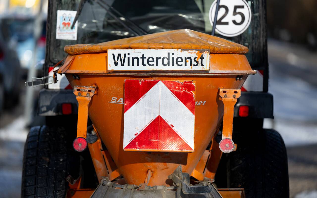 Ein Schneeräumfahrzeug vom Winterdienst der Stadt München steht auf einem Fußweg.
