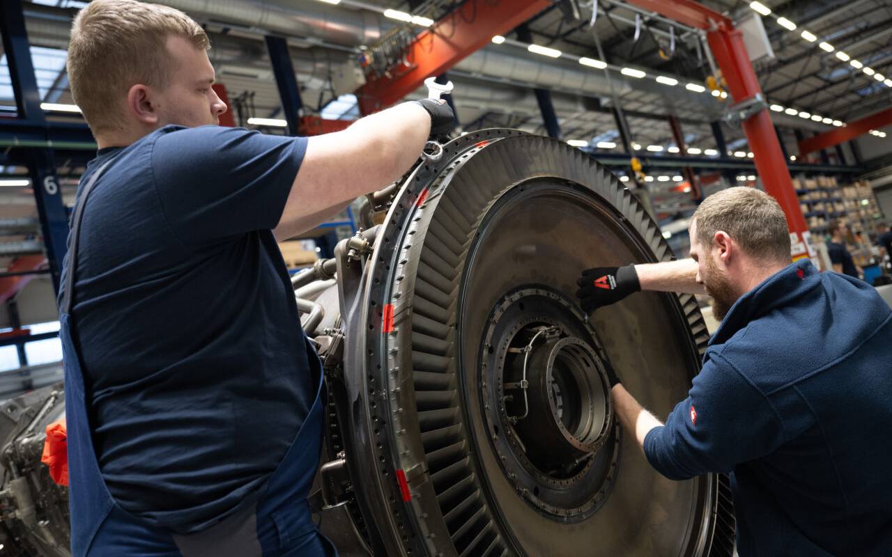 Mitarbeiter arbeiten bei MTU Maintenance Berlin-Brandenburg an einem Antrieb,