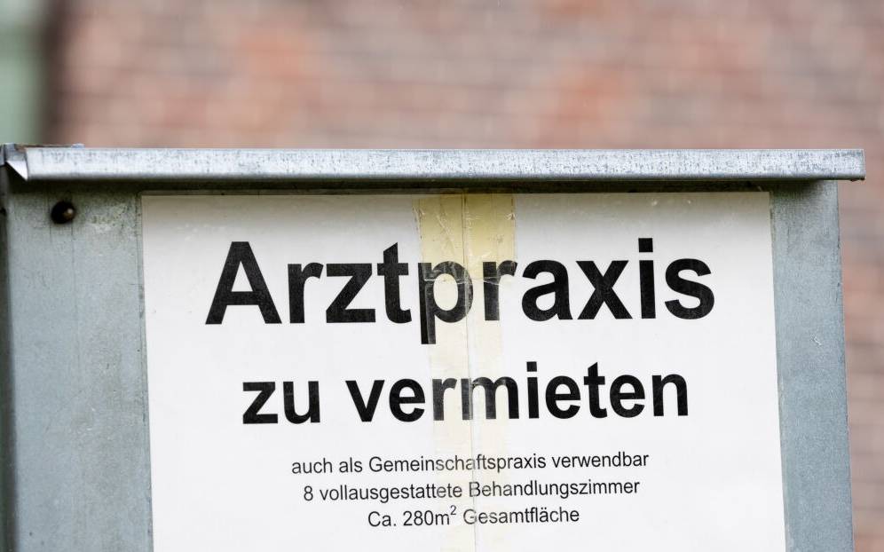 Ein Schild mit der Aufschrift «Arztpraxis zu vermieten» steht vor einem Gebäude.