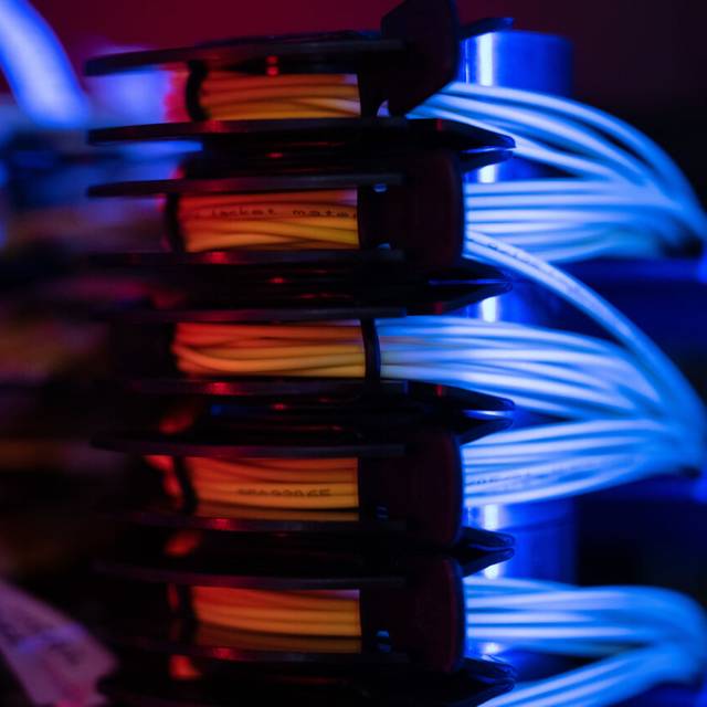 Glasfaserbündel liegen in einem Serverschrank.