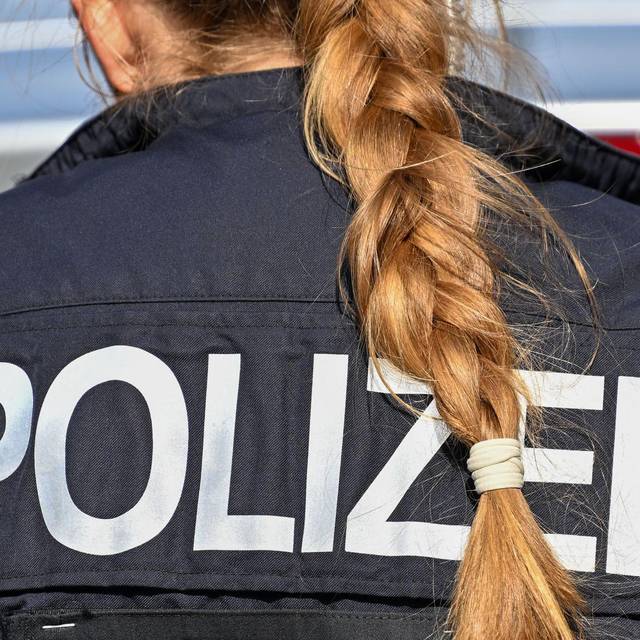 Der Zopf einer Polizistin hängt über ihre Uniform.