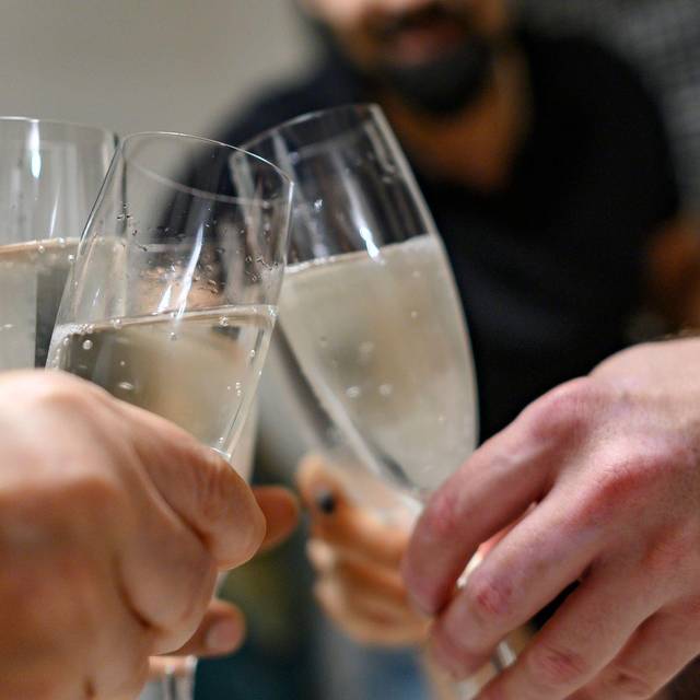 Mehrere Personen halten Sektgläser in den Händen