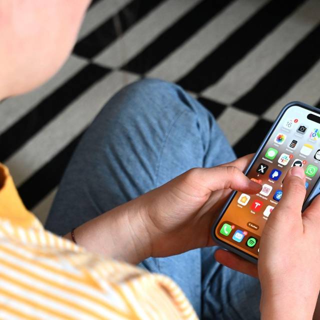 Eine Jugendliche sitzt am Smartphone (Archivbild)