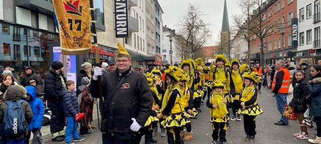 Eine Kindertanzgruppe mit mehreren Erwachsenen trägt schwarz-gelbe Kostüme.