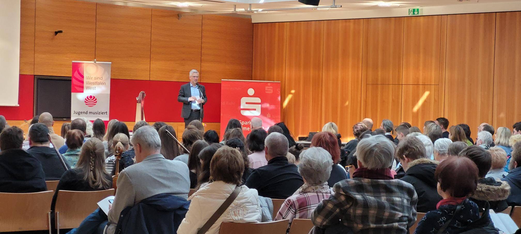 Oberbürgermeister Erik O. Schulz steht auf der Bühne der Sparkasse Hagen und bedankt sich für das Preisträgerkonzert Jugend Musiziert sowie die MusikerInnen, die am Wettbewerb teilnehmen