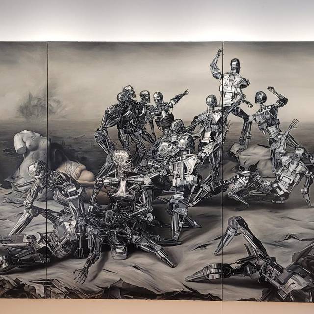 Zu sehen ist ein Bilde vom chinesischen Künstler Zhou Song. Darauf sieht man roboterähnliche Krieger, die miteinander kämpfen, eine Atombombe und eine tote, menschliche schwangere Frau.