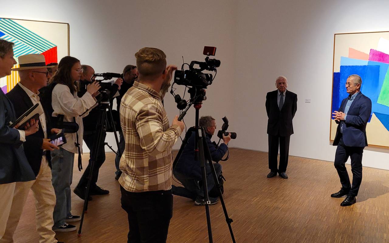 Zu sehen sind verschiedene Reporter, und Heinz Mack und Museumsdirektor Tayfun Belgin vor einem Gemälde Macks.