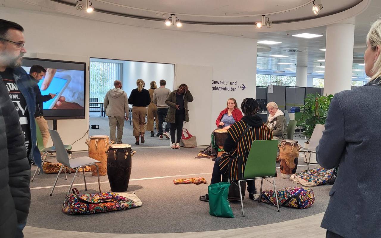 Zu sehen sind Leute in einem Sitzkreis, die auf Trommeln spielen, im neuen Volme-Forum, im Rahmen eines Workshops.