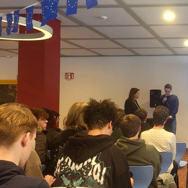 Man sieht Katarina Barley und Ina Blumenthal, die auf dem Podium in der Mensa der Gesamtschule Wehringhausen mit zwei Schülermoderatoren diskutieren