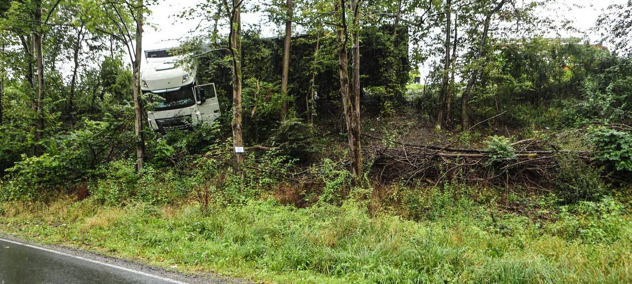 Ein Lkw hängt zwischen mehreren Bäumen