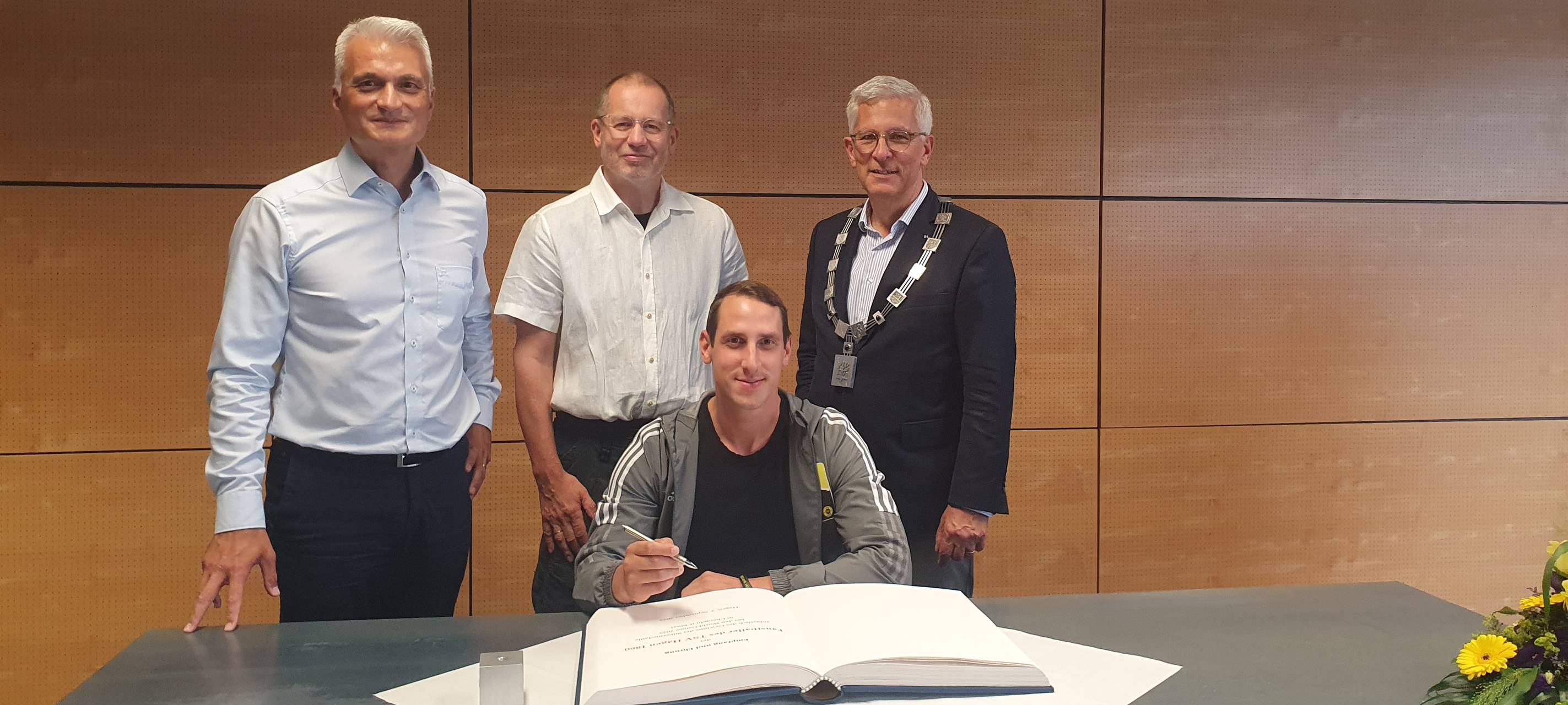 Sportler tragen sich ins goldene Buch ein