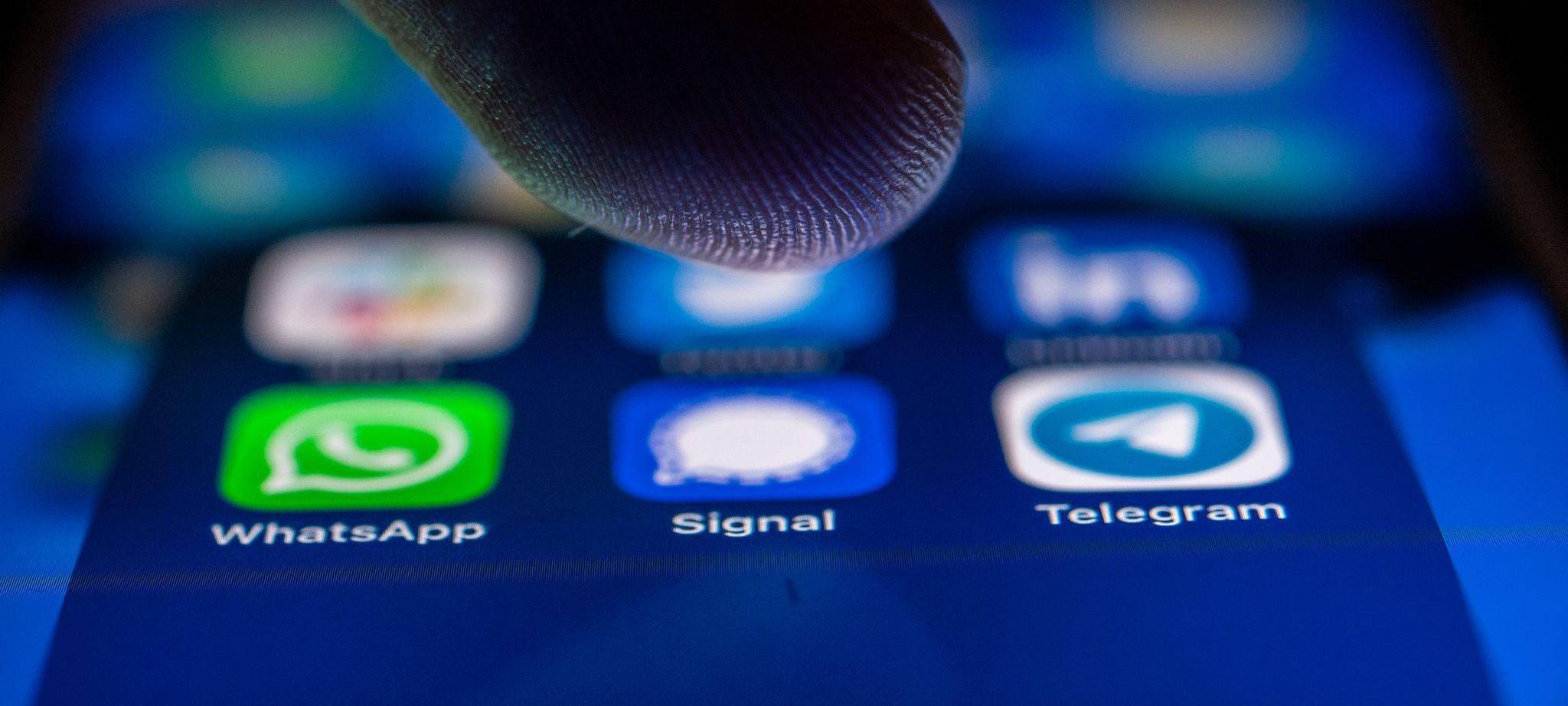 Ein Finger schwebt über dem Icon der Signal-App