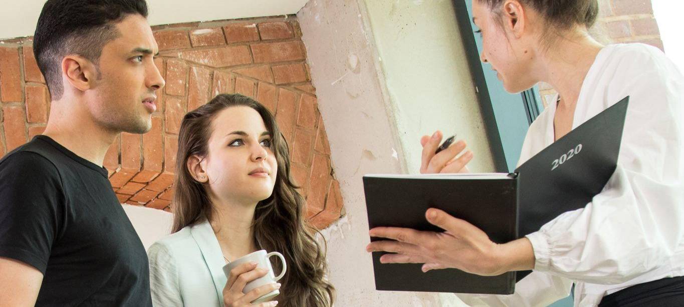 Drei Kollegen schauen in einen Terminplaner