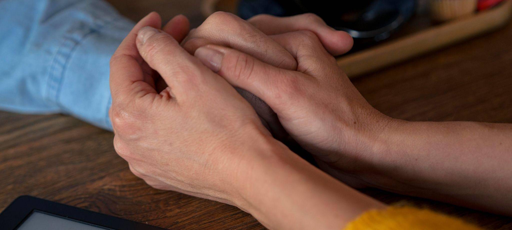 Zwei Personen halten sich an den Händen