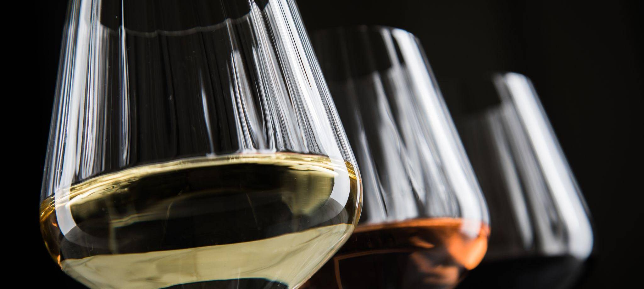 Verschiedene Weingläser stehen auf einem Tisch