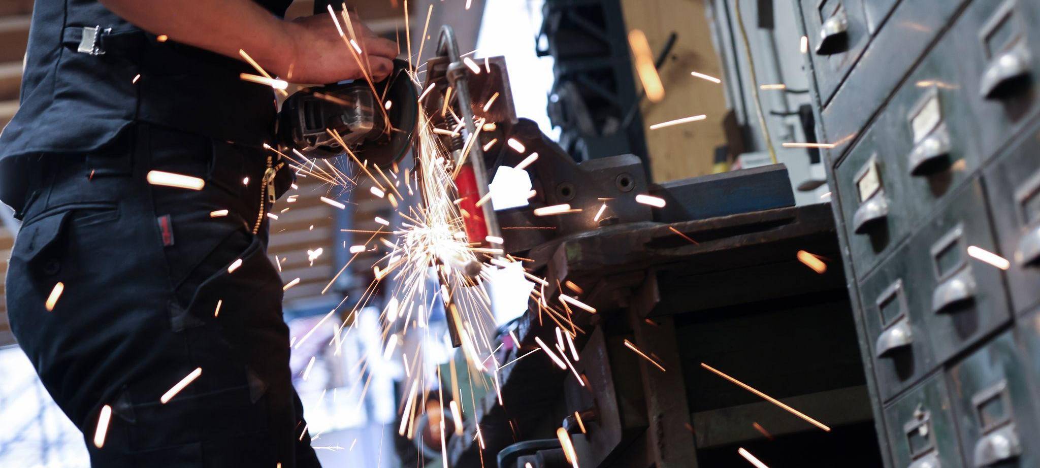 Kunstschmied arbeitet mit einem Winkelschleifer