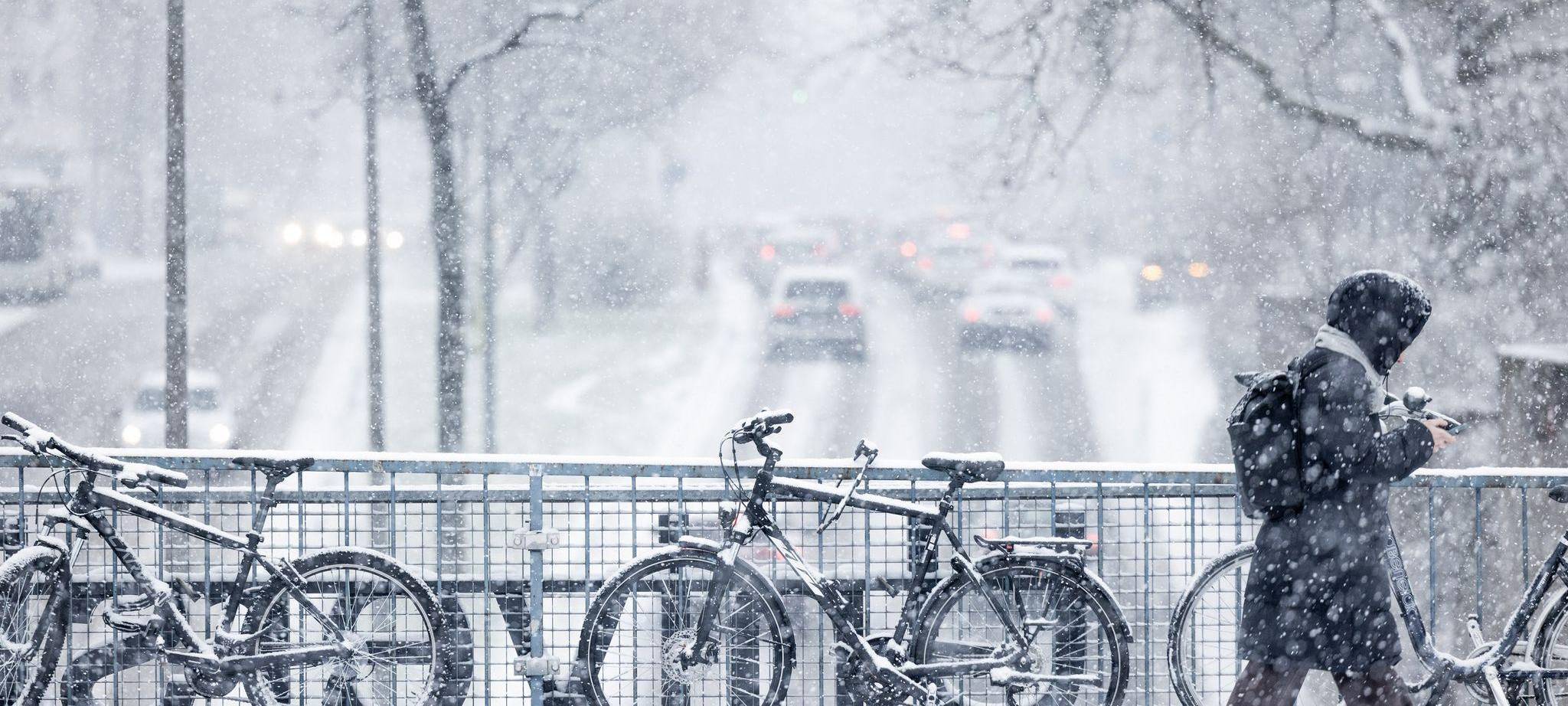 Schneebedeckte Fahrräder im dichten Schneetreiben