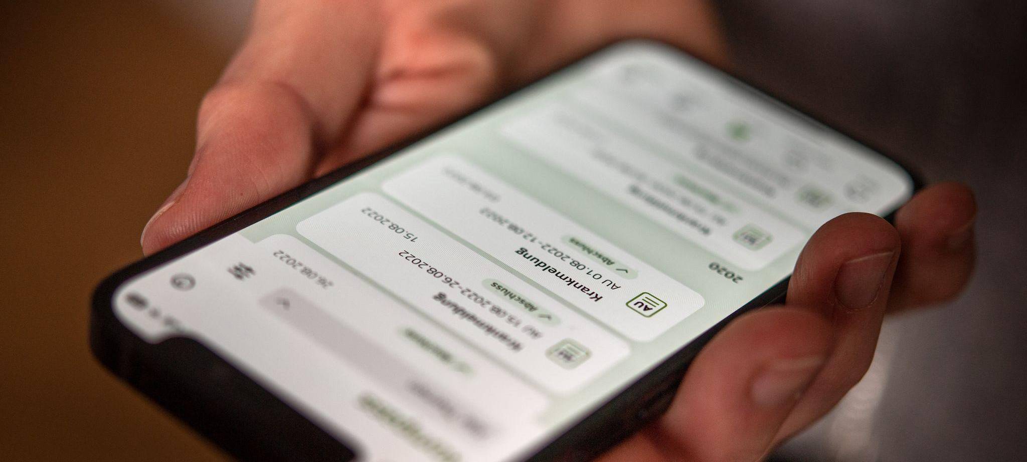 Eine elektronische AU ist auf dem Display eines Handys zu sehen