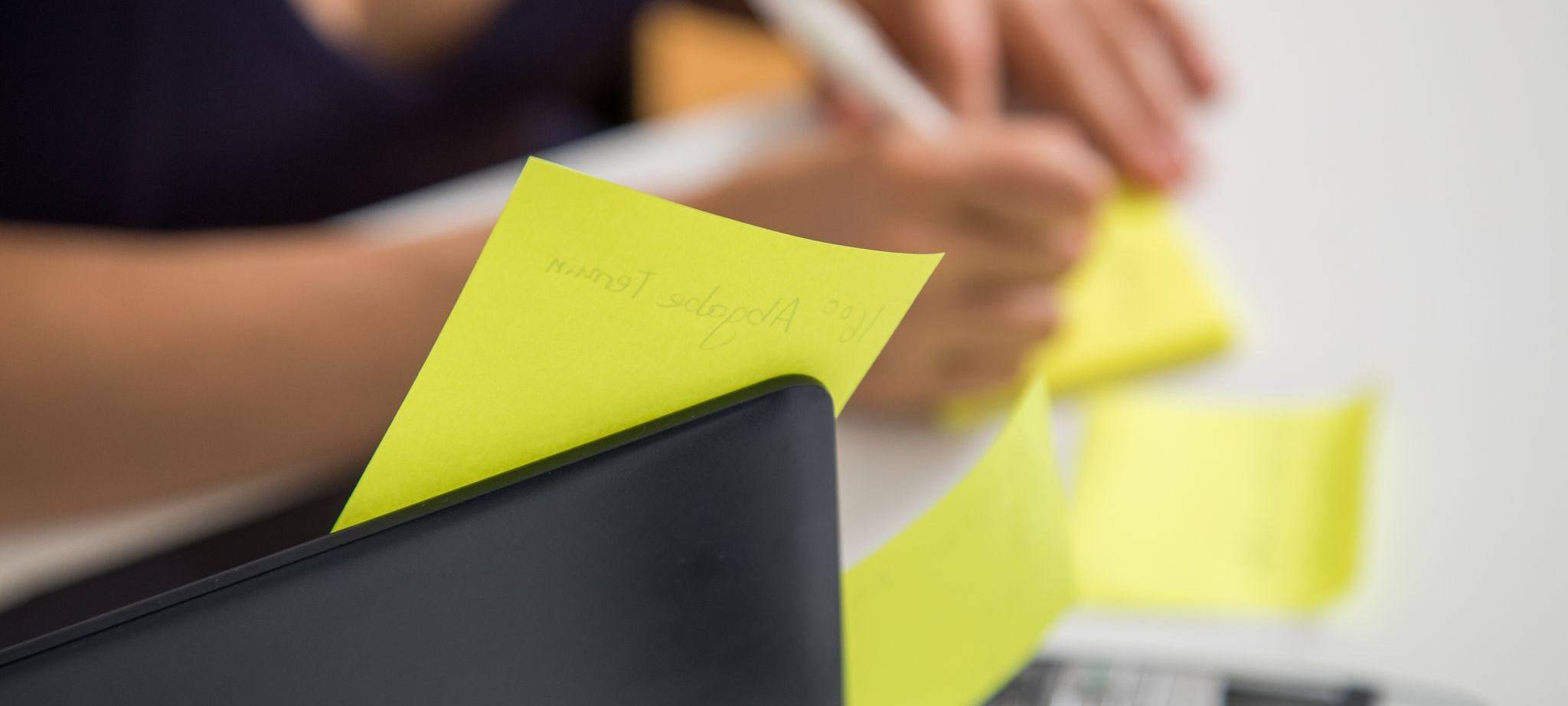 Eine Frau schreibt auf Klebezettel