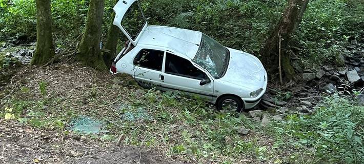 Beschädigtes Auto im Bachlauf.